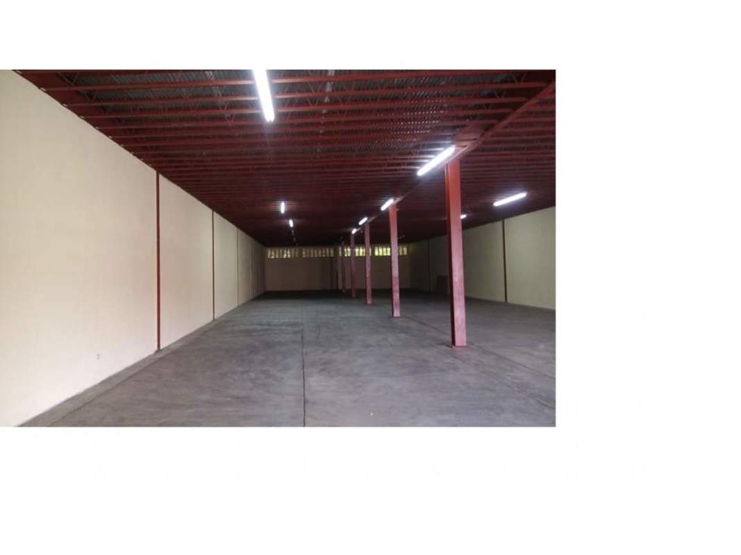 Empty large open warehouse floor with lighting and support columns in Panama City