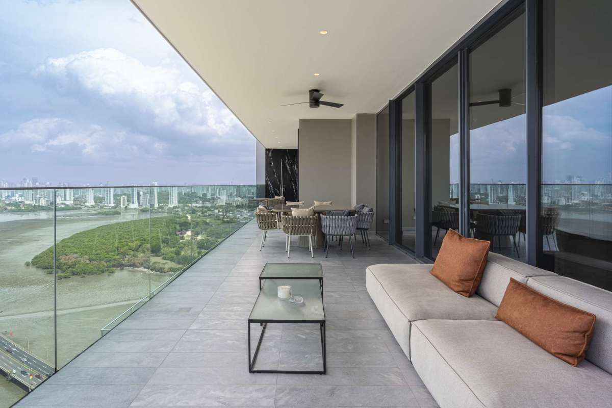 Contemporary open-plan living and dining room with floor-to-ceiling windows and ocean views at Upper East Costa del Este penthouse