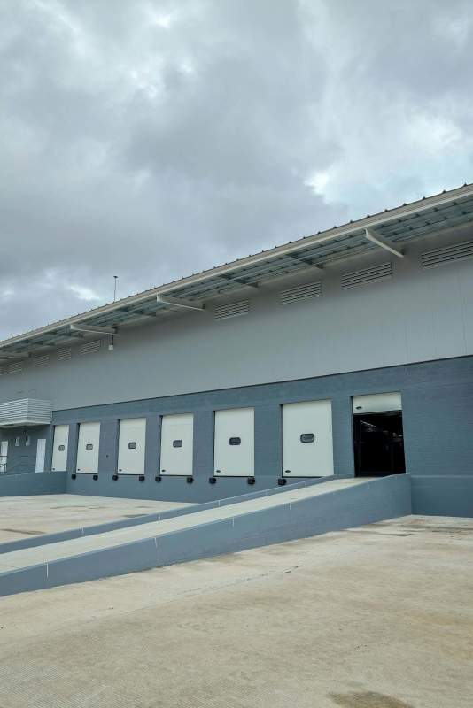 Modern industrial warehouse exterior with truck loading docks Llano Bonito Panama