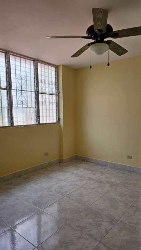Traditional apartment kitchen with tiled backsplash, beige walls, ceiling fan and cabinets Betania Panama