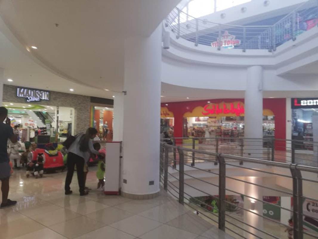 Commercial corridor in Los Andes Mall with escalators, multiple storefronts Panama