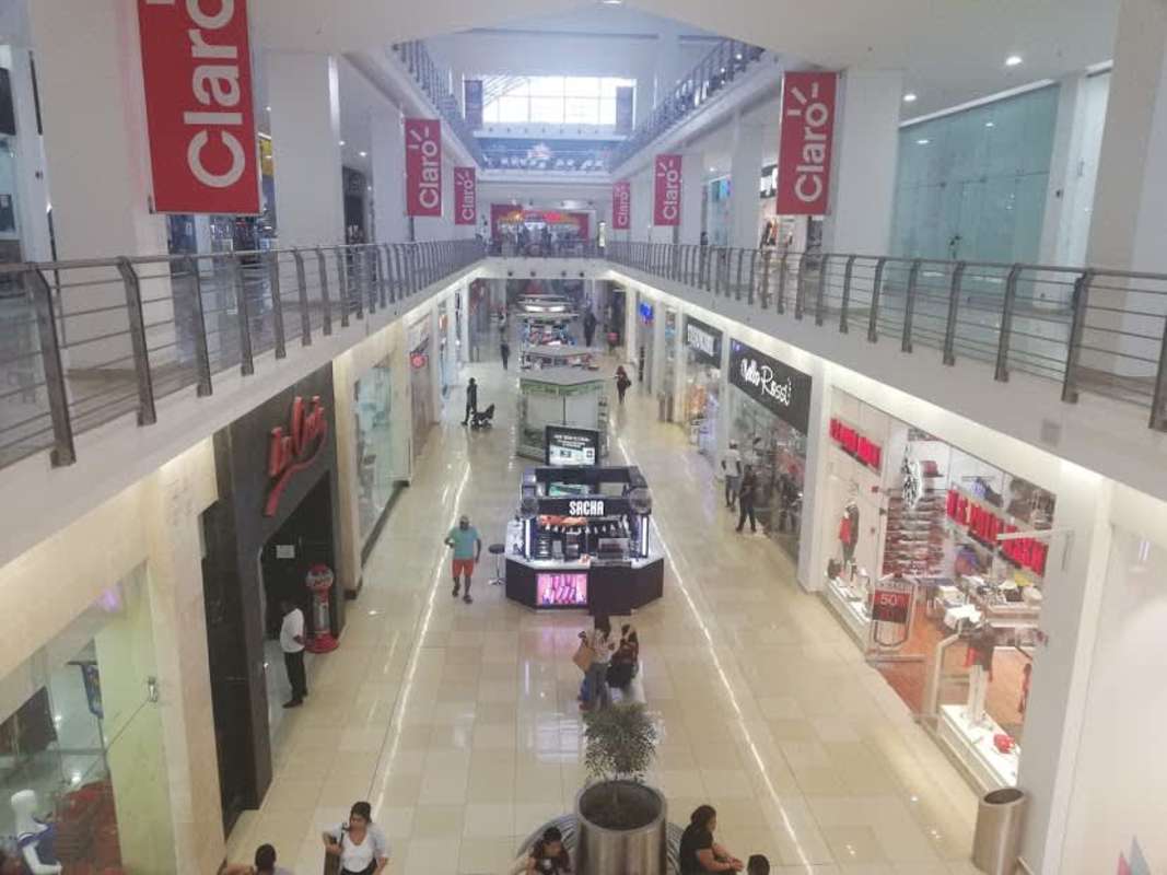 Interior view of shopping mall with skylights, multiple retail stores Los Andes Panama