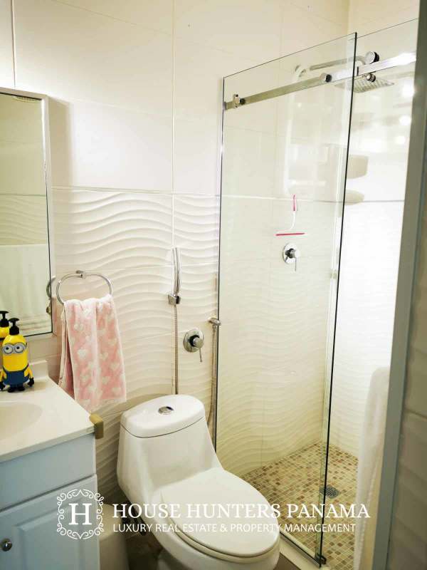 Contemporary bathroom with glass shower, vanity and textured tiles at PH Keops Tower Panama