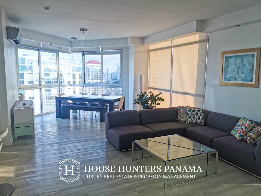 Open concept living and dining room with large windows in PH Keops Tower Panama City