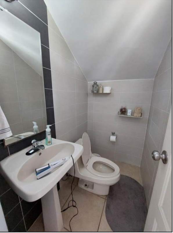 Compact powder room with mirror and pedestal sink in duplex Brisas del Golf Panama