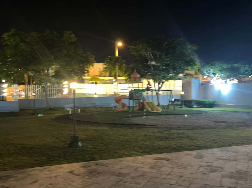 Swimming pool with palm trees and tennis court illuminated in Brisas Norte Panama