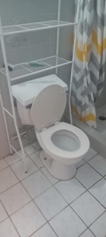 Bathroom area with toilet, tiled floor, shower curtain at Casa 25 La Castellana