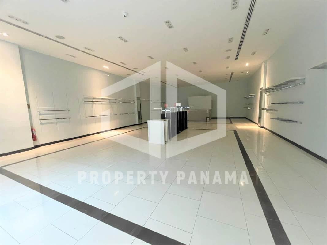 Unfurnished modern retail unit inside Albrook Mall with tiled floors, display fixtures and central counter