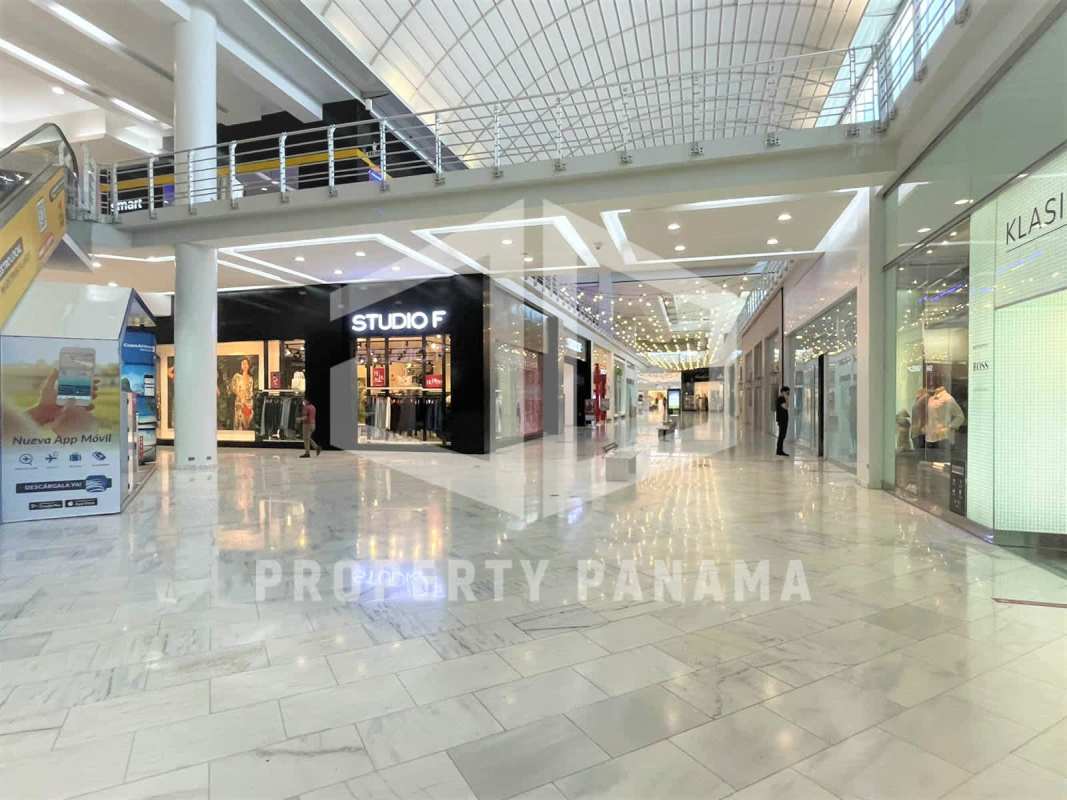 Spacious Albrook Mall shopping corridor with skylight, multiple stores, marble flooring in Panama City