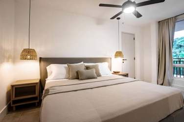 Modern minimalist bedroom with large window, queen bed, ceiling fan Blue Venao Playa Venao