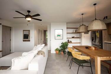 Bright minimalist living dining area white walls sofa pendant lights Blue Venao Panama