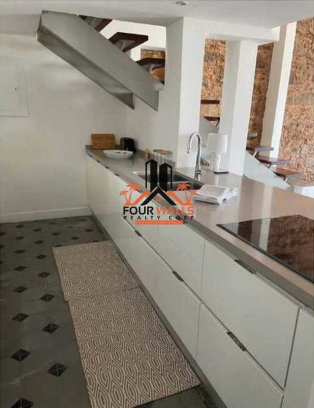 Kitchen with white cabinets, stone accent wall, built-in appliances PH Casa Episcopal Casco Viejo