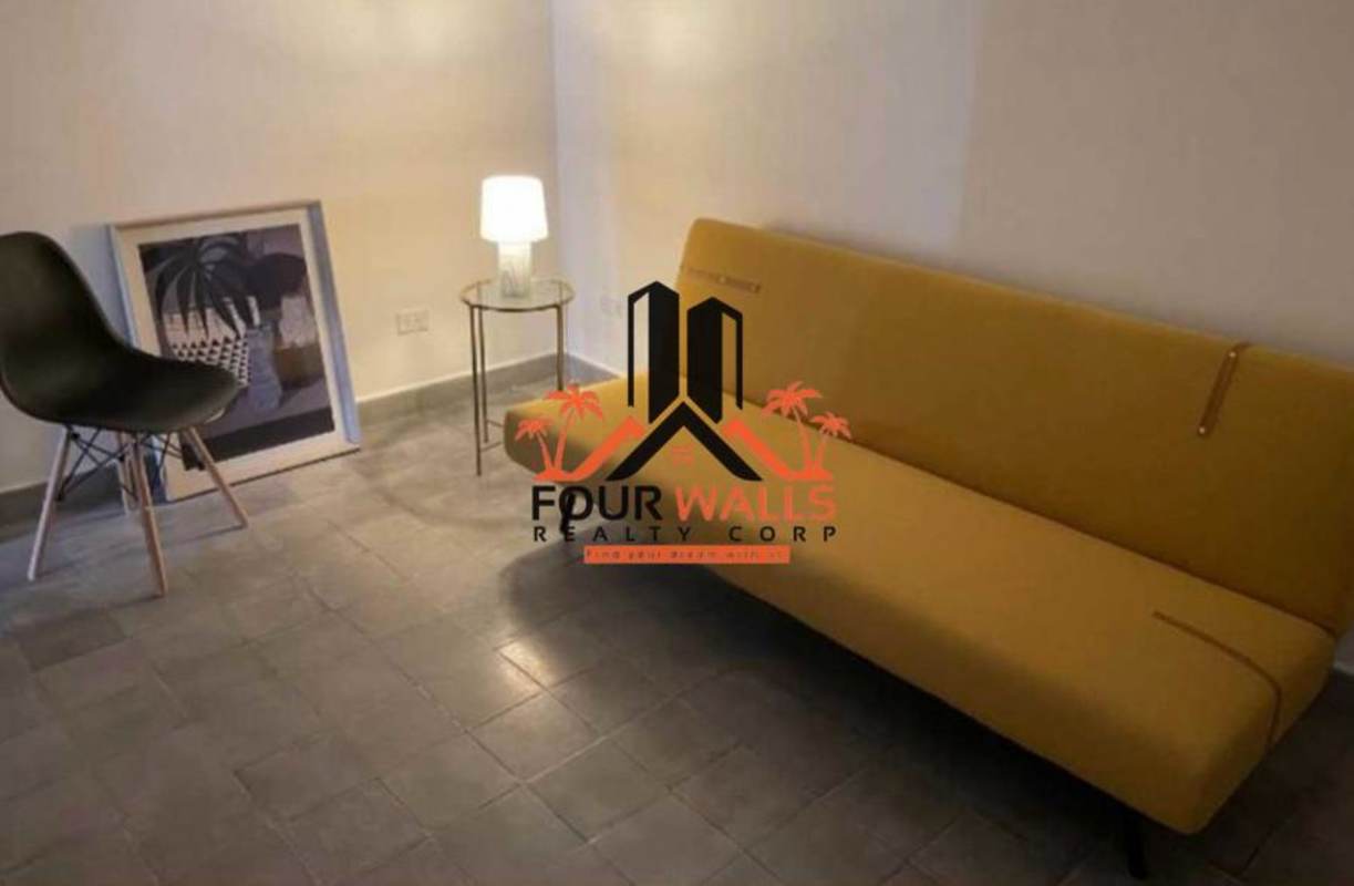 Open plan living area with exposed brick, balcony access, modern furniture PH Casa Episcopal Casco Viejo