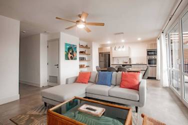 Comfortable living area with sectional sofa, ceiling fan, large windows and balcony access at Playa Venao