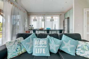 Spacious living room with vaulted ceiling, sectional sofa, beach decor at Blue Venao Playa Venao Panama