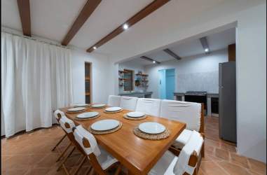 Open kitchen and dining rustic beams terracotta tile inside beachfront villa Pedasí Panama