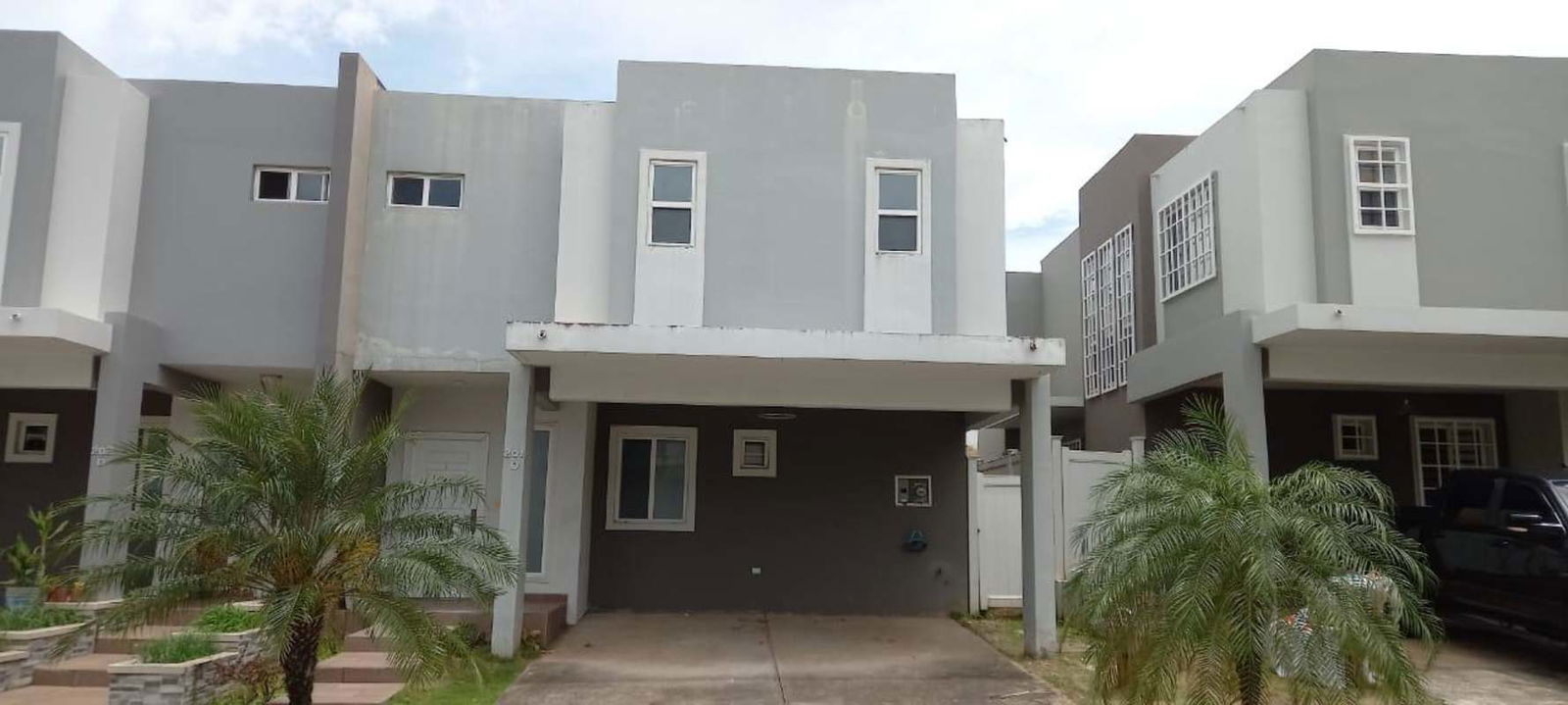 Double story townhouse facade with covered parking at PH Victoria Brisas del Golf Panama for sale