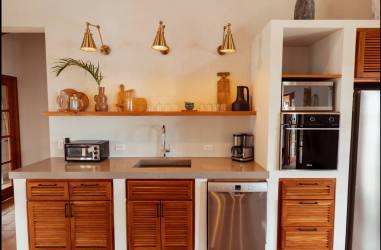 Open kitchen with island, wooden cabinetry, stainless appliances in Casa Serena Pedasí Panama