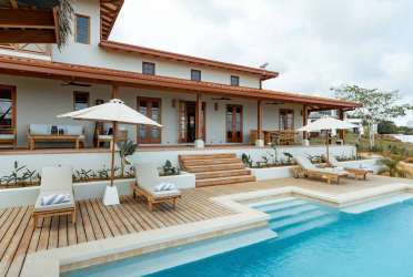 Island kitchen with stainless appliances and wooden cabinets at Casa Serena Pedasí Panama