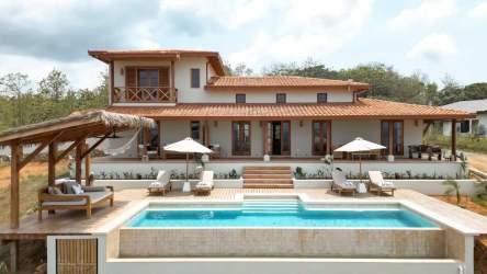 Primary bedroom with vaulted ceiling, French doors, coastal decor in Casa Serena Pedasí Panama