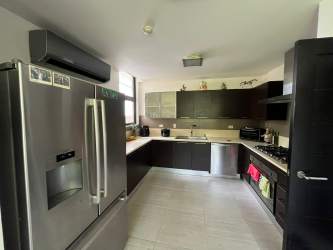 Living room with large windows, traditional sofa set and natural light in PH Nativa Panama Pacifico