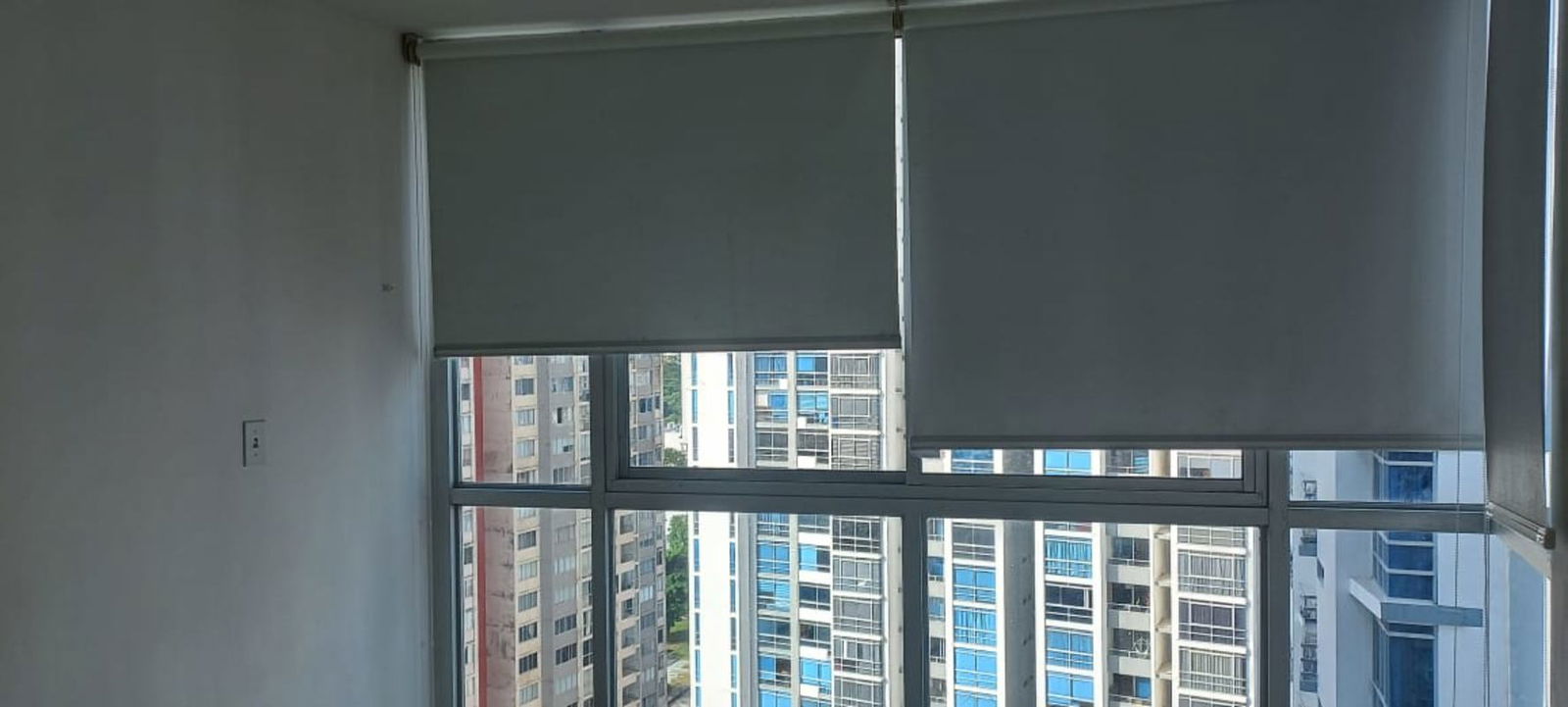 Bedroom with floor-to-ceiling windows and blinds with urban view in PH Coral Towers Carrasquilla Panama