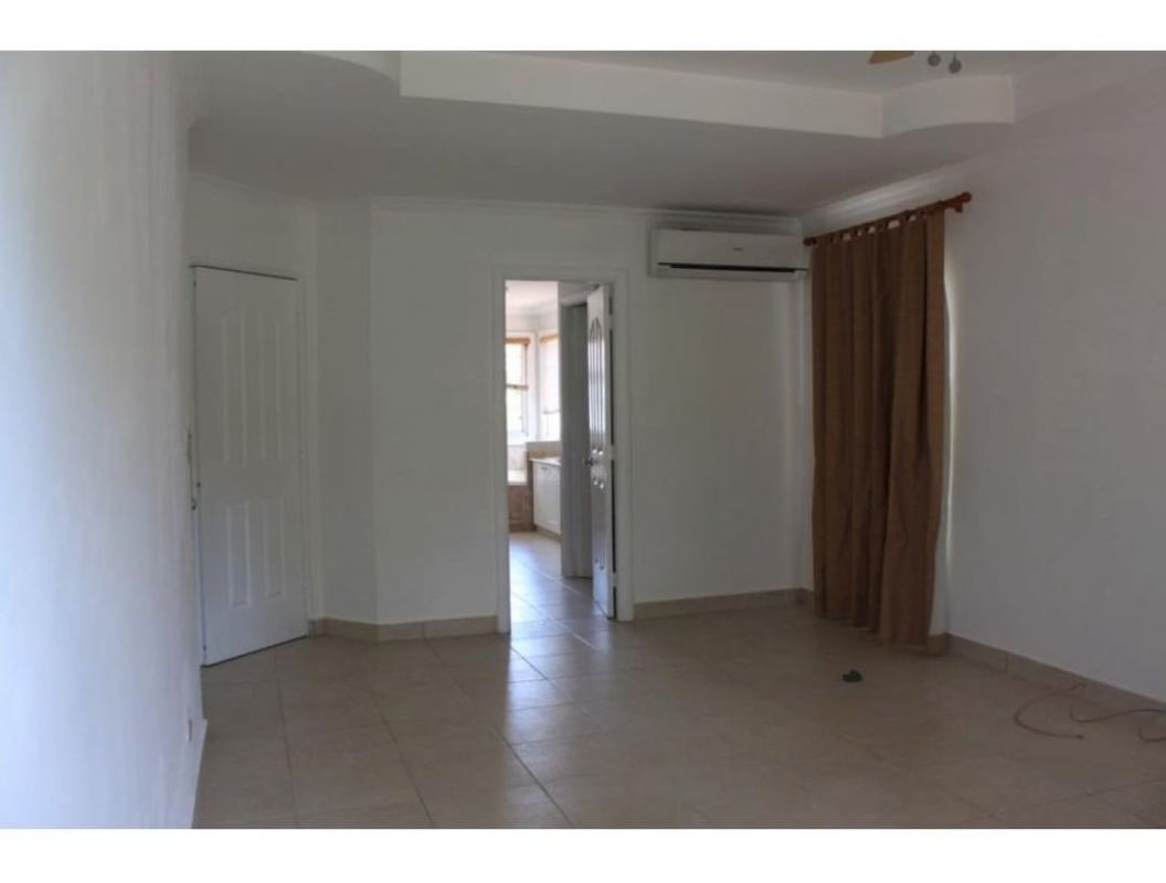 Spacious modern kitchen with white cabinetry black countertops and island Costa Azul Panama