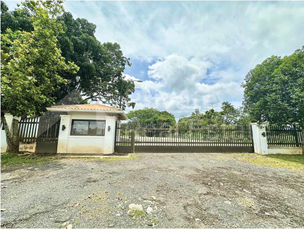 Large flat vacant commercial land with perimeter fencing trees and open sky Rancho Café Panama