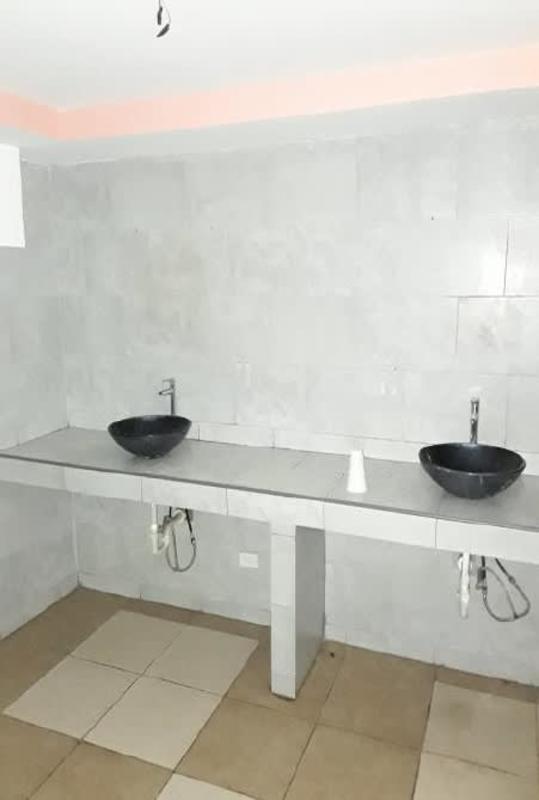 Bathroom with black vessel sinks and gray tile in commercial property San Francisco Panama