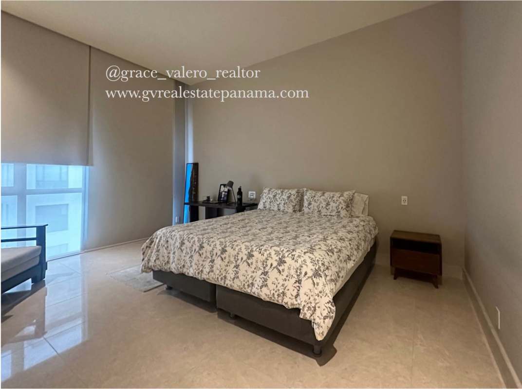 Bright bedroom with king-size bed, large window and roller blinds in luxury tower Santa María Panama