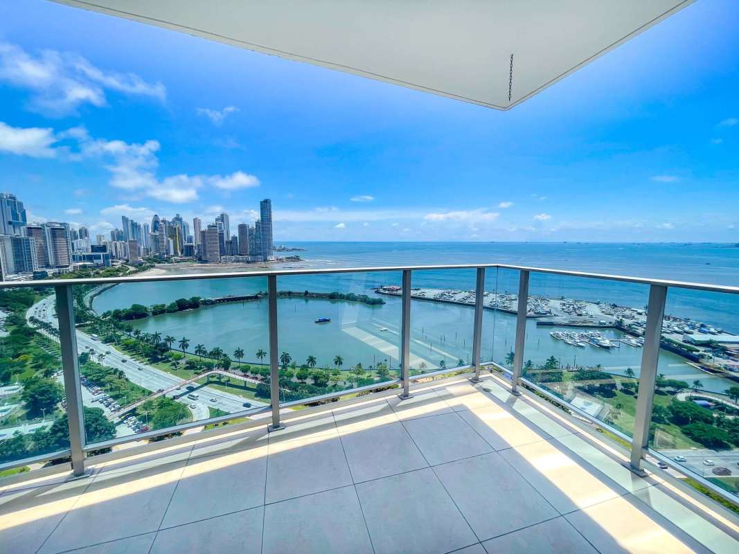 Apartment dining area with full wall windows facing city skyline and Pacific Ocean in PH White Tower Panama City