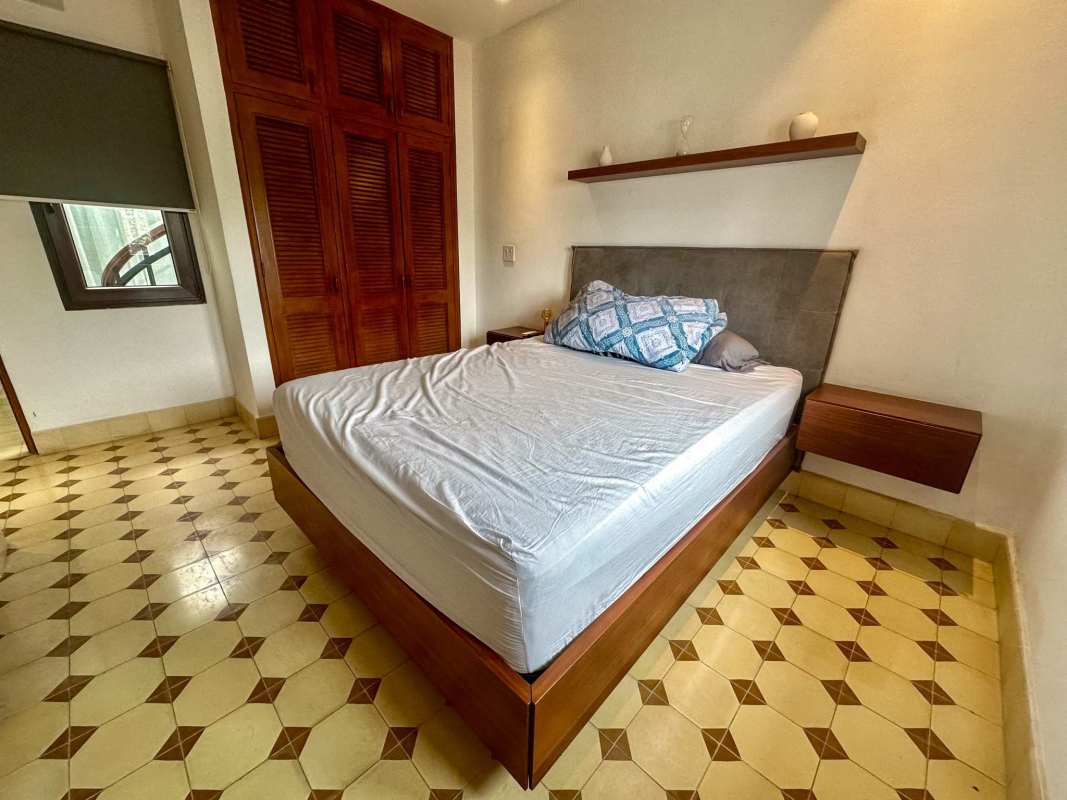 Bedroom with wooden wardrobe, patterned tiles, Casco Viejo historic loft apartment Panama
