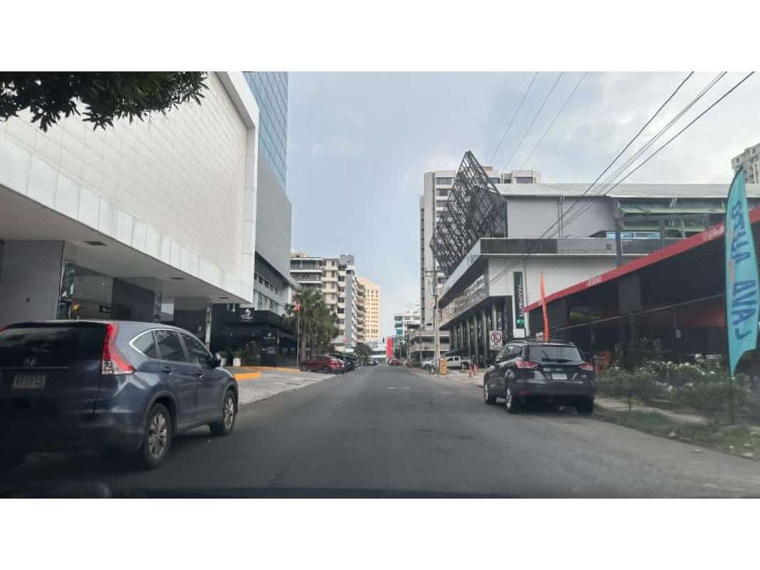 Modern commercial buildings, storefronts, parked cars, busy street in Obarrio financial district of Panama City