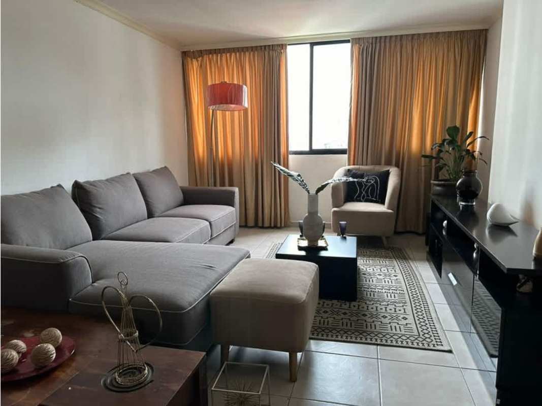 Living area with sofa, large window, natural light in Panama City apartment