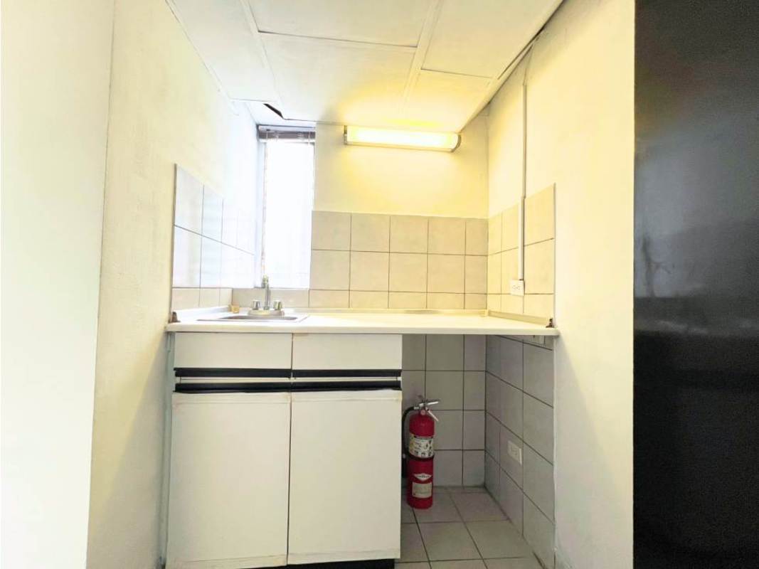 Compact kitchenette with tile backsplash and white cabinetry at PH Advanced Panama City