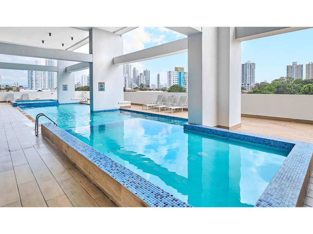 Rooftop landscaped garden with palm trees and skyline backdrop at PH Midpark Carrasquilla