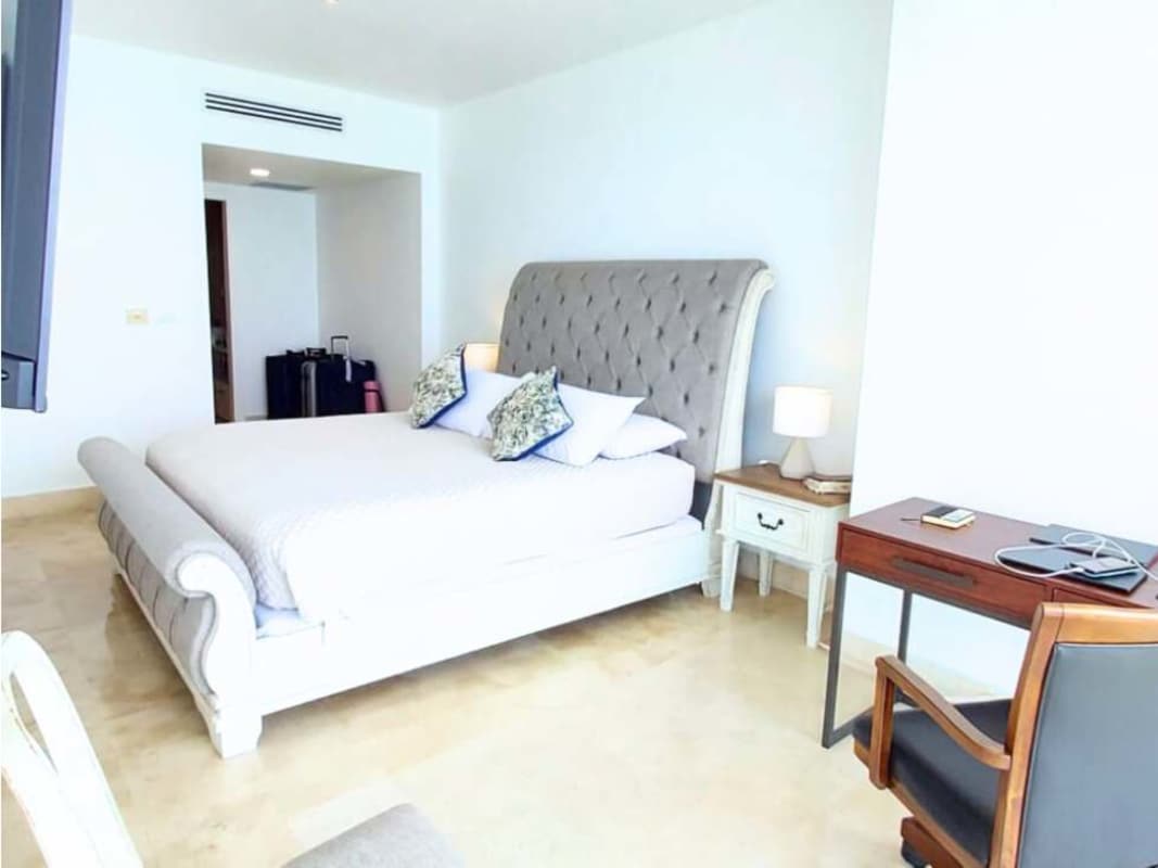 Bright bedroom with upholstered bed, workspace, and balcony access at PH Yoo Panama