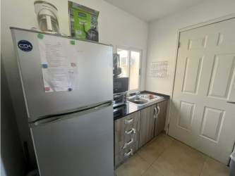 Small kitchen with wood cabinets, granite countertops, and appliances in Coronado real estate