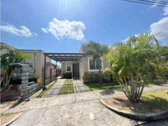 Front facade of Coronado beach house with driveway and palm trees for sale in Paraiso Village