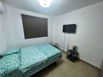 Bedroom with large window, tile flooring and neutral palette in Coronado beach property