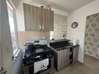Kitchen with wood cabinetry, granite counters, refrigerator and stove in Paraiso Village Coronado house