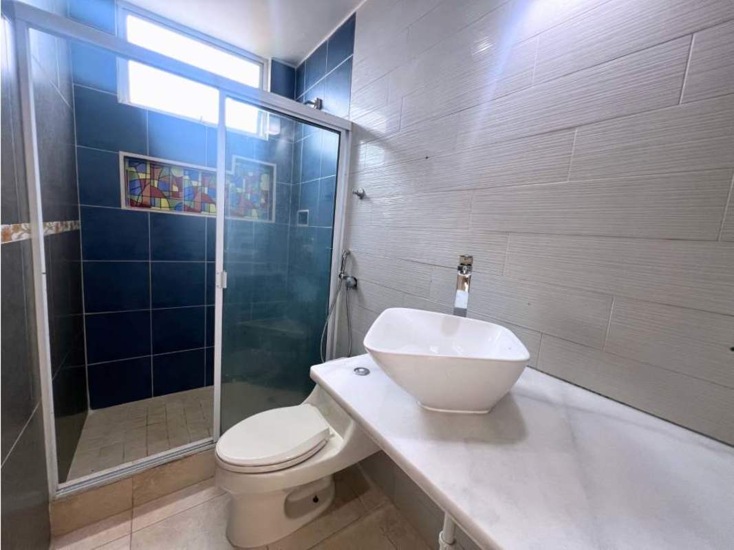 Bathroom with blue tile accents, modern vessel sink, glass shower enclosure in PH Portofino San Francisco Panama