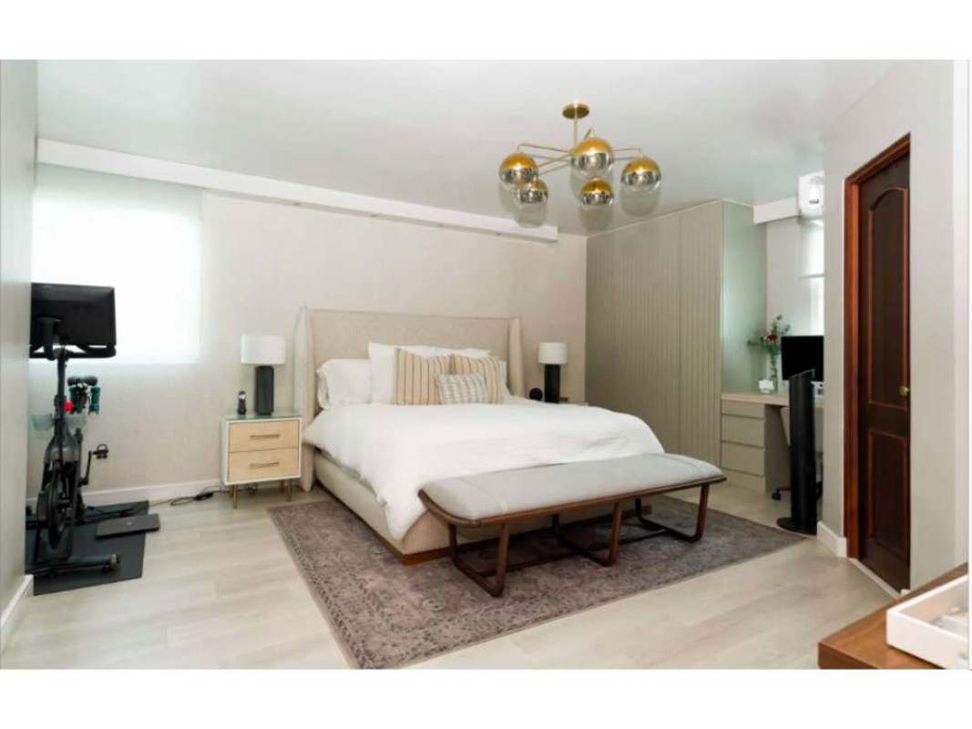 Master bedroom with bed, chandelier, workout area office desk PH Bahía Obarrio Panama