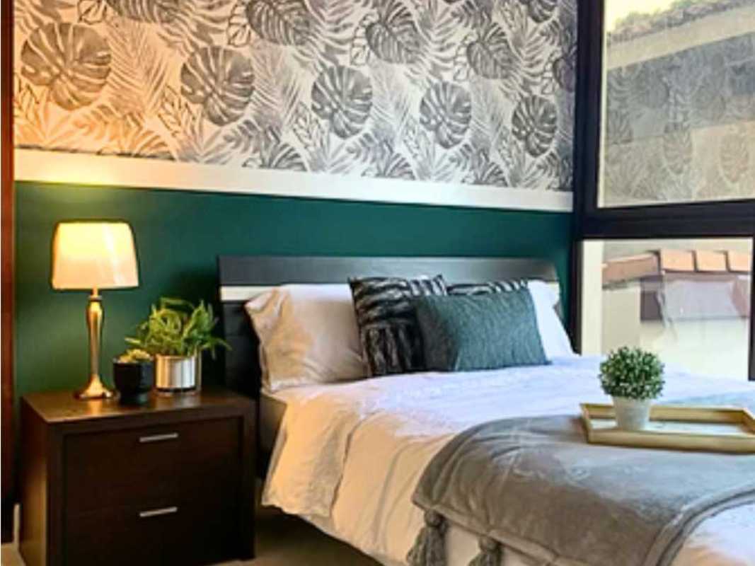 Bedroom with tropical leaf wallpaper green and wood decor in Mareas Beach Club Coronado Panama