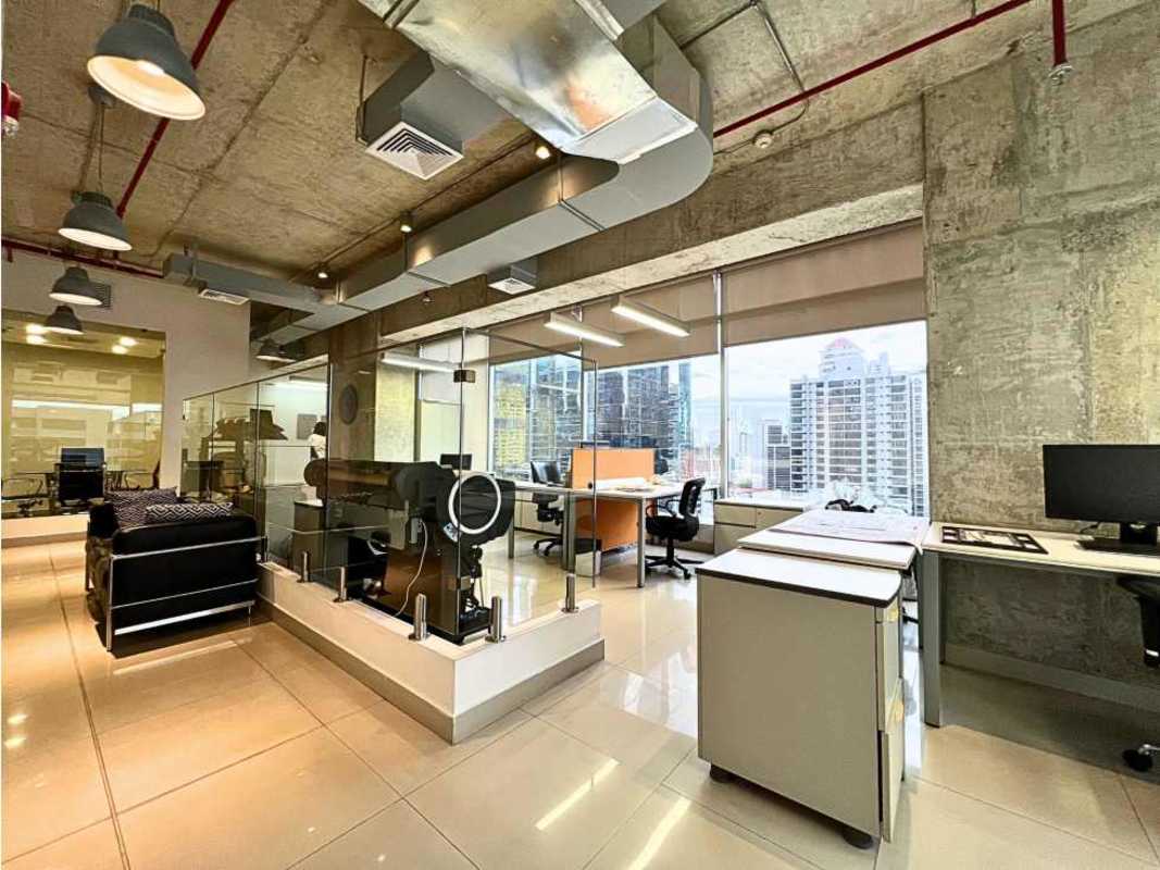 Open plan office area with industrial ceiling, floor-to-ceiling windows and city skyline view in Sortis Business Tower Panama