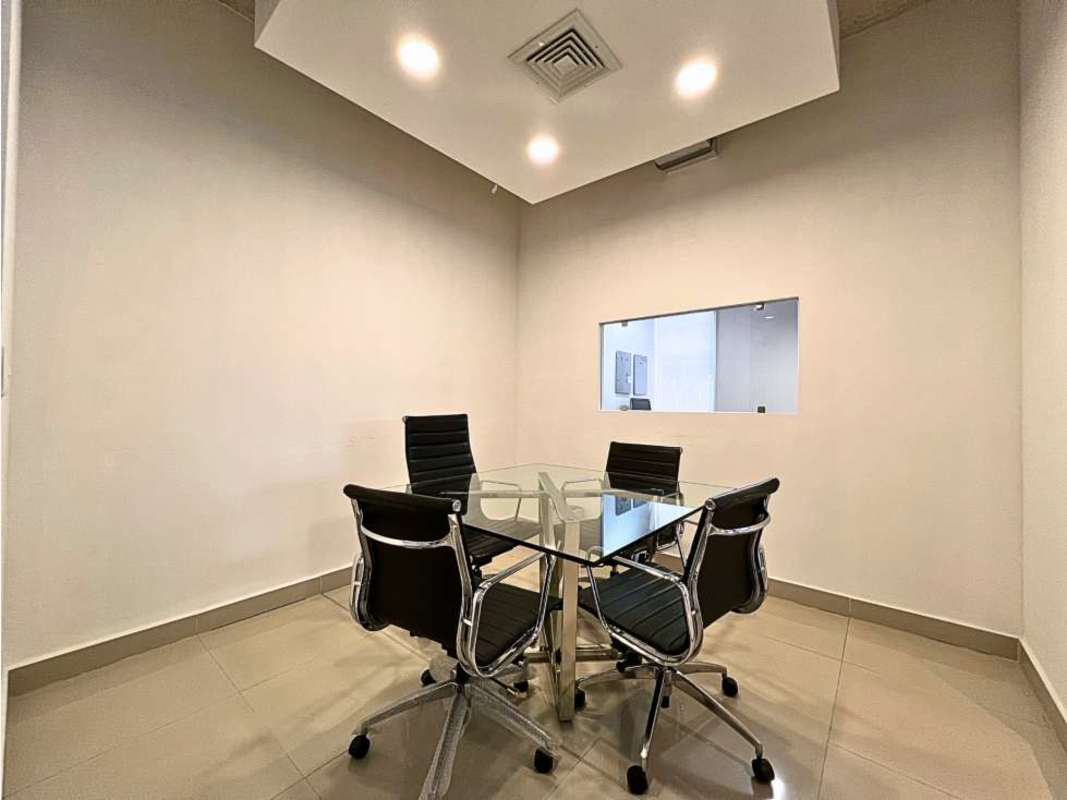 Modern minimalist office meeting room with glass wall divider and round glass conference table in Sortis Business Center Obarrio Panama