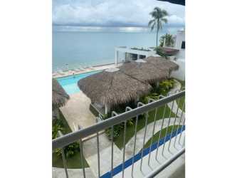Living room with couch, TV, balcony access and ocean views at Playa Blanca Condo Panama