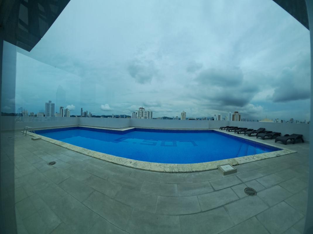 Rooftop swimming pool with loungers overlooking skyline in PH El Cangrejo Tower Panama