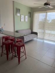 Furnished living room with glass doors and sea view in Playa Caracol condo Panama