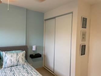 Bedroom with blue accent wall bed fan and AC Playa Caracol beachfront condo Panama